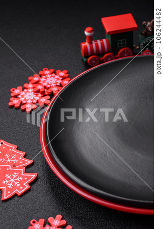 Empty ceramic black plate with christmas decoration elements 106244482