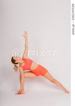Full length portrait of smiling young woman in sportswear isolated over studio background. Full length portrait of smiling young woman in sportswear isolated over studio background. 106244599