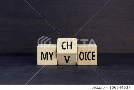 My voice and choice symbol. Businessman turns wooden cubes and changes the concept word my choice to voice. Beautiful grey table grey background, copy space. Business and my voice choice concept. 106244637