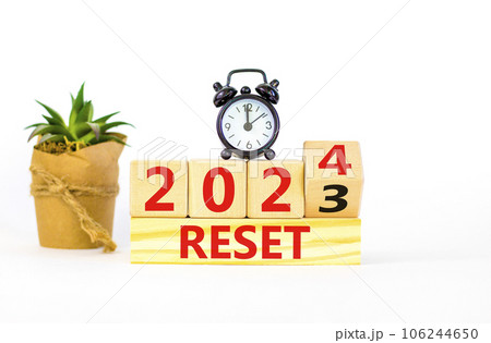 2024 reset new year symbol. Businessman turns a wooden cube and changes words Reset 2023 to Reset 2024. Beautiful white table white background, copy space. Business 2024 reset new year concept. 106244650