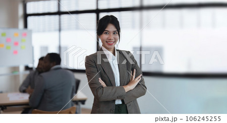 Pretty young Asian business woman standing a confidence in the office with a diversity ethnicity background Pretty young Asian business woman standing a confidence in the office with a diversity ethnicity background 106245255