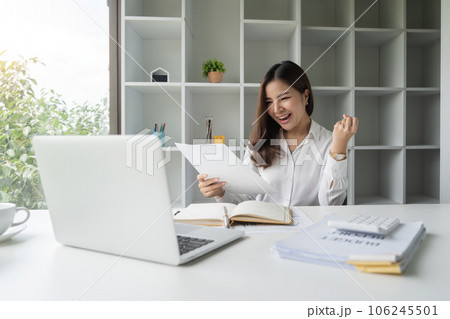 Happy asian businesswoman raising hands with victory smiling happily with documents in hand. The concept of success at work Happy asian businesswoman raising hands with victory smiling happily with documents in hand. The concept of success at work 106245501