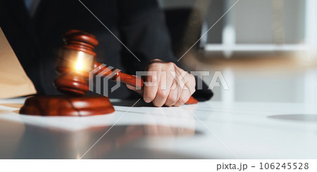 Photography of a judge hold judges gavel with justice lawyers at law firm in background. concepts of law Photography of a judge hold judges gavel with justice lawyers at law firm in background. concepts of law 106245528