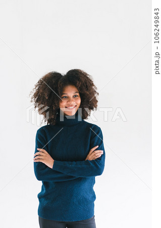 Studio portrait of confident young African American woman smiling at camera standing arm crossed on white background. Studio portrait of confident young African American woman smiling at camera standing arm crossed on white background. 106249843