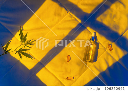 Night bedroom, a bottle of cannabis oil, cannabis branch in moonlight Night bedroom, a bottle of cannabis oil, cannabis branch in moonlight 106250941