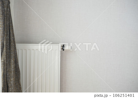 White radiator on grey white wall. apartment heating installation system,  106251401