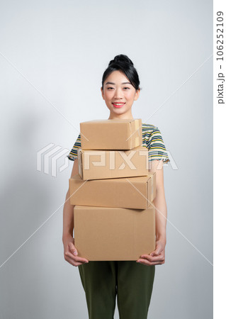 Happy cute asian woman smiling and holding package online marketing and delivery Happy cute asian woman smiling and holding package online marketing and delivery 106252109