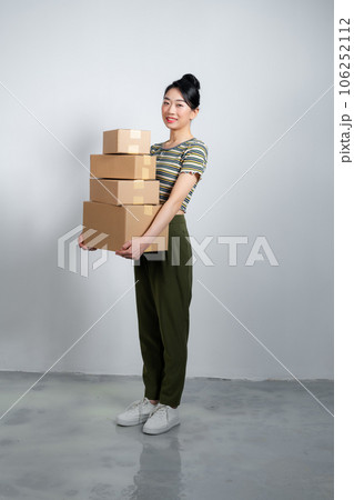 Happy asian woman holding pile of boxes, concept of delivery, shopping or business, white background 106252112