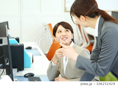 打ち合わせをする先輩と新人女性会社員のイメージ 106252429