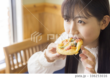 カフェでピザパンを食べる若い女性　女子大生 106253016