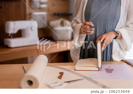Asian tailor women creative and designing new fashion collection while drawing sketch in notebook Asian tailor women creative and designing new fashion collection while drawing sketch in notebook 106253649