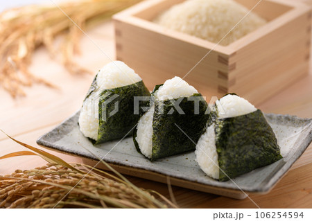 手作りおむすび 海苔を巻いたおにぎりと 枡に盛った米 ( オニギリ ) たくあんを添えて 106254594