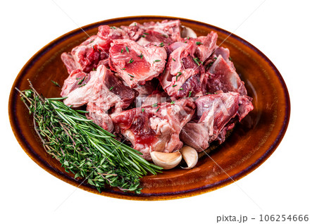 Raw mutton meat diced for goulash or stew with bone on a rustic plate. High quality Isolate, white background. Raw mutton meat diced for goulash or stew with bone on a rustic plate. High quality Isolate, white background. 106254666