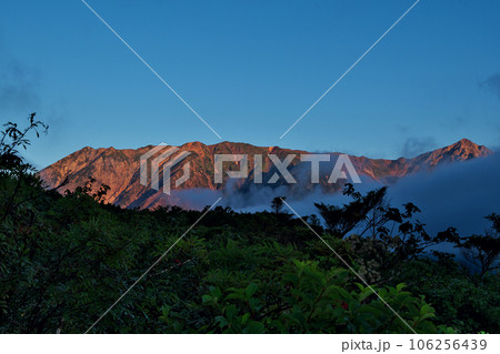 朝日に照らされる白馬三山のモルゲンロート 106256439