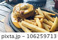 presentation of hamburger with melted cheese on top 106259713
