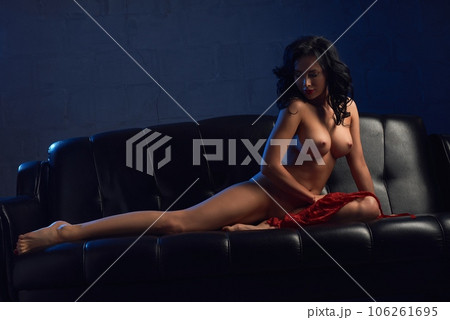 Naked fit model laying on black sofa 106261695