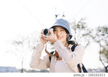 Young adult asian woman traveller wear blue hat and backpack travel in city using camera Young adult asian woman traveller wear blue hat and backpack travel in city using camera 106262011
