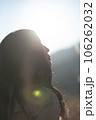 逆光の中上を向く黒髪の女性 106262032