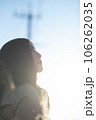 逆光の中上を向く黒髪の女性 106262035