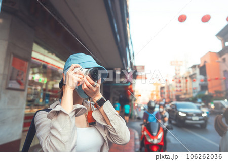 Young adult asian woman traveller backpack using camera photography in city Young adult asian woman traveller backpack using camera photography in city 106262036