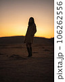 夕焼けの草千里、コートを着た女性のシルエット 106262556
