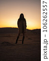 夕焼けの草千里、コートを着た女性のシルエット 106262557