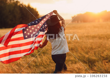 Woman with american flag on the field at sunset. Labor day concept. 106263158