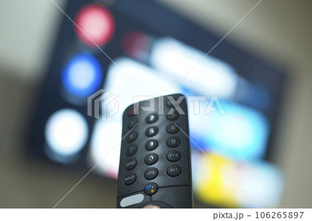 Hand with TV remote control, switching TV series from streaming service platform. The new way of enjoying entertainment at home. 106265897