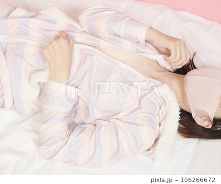 パジャマのファスナーを下ろす若い女性 106266672