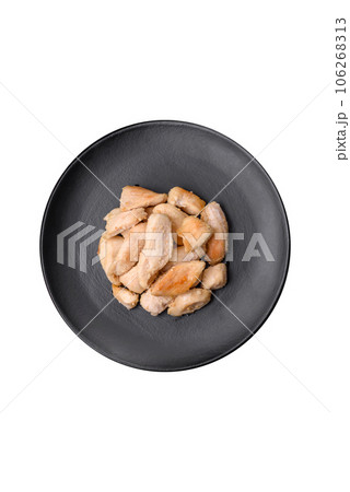 Delicious chicken slices baked with spices and herbs on a round ceramic plate Delicious chicken slices baked with spices and herbs on a round ceramic plate 106268313