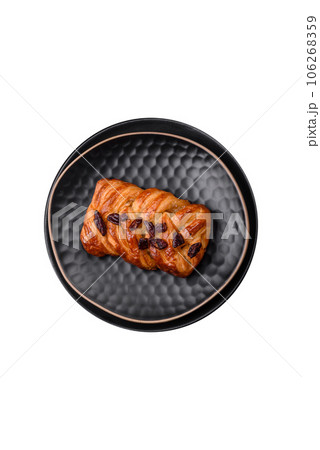 Delicious fresh baked pigtail bun with nuts and syrup 106268359