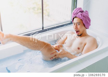 Funny asian man being childish and playful in a bathtub. Funny asian man being childish and playful in a bathtub. 106269170