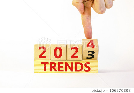 2024 trends new year symbol. Businessman turns a wooden cube and changes words Trends 2023 to Trends 2024. Beautiful white table white background, copy space. Business 2024 trends new year concept. 106270808