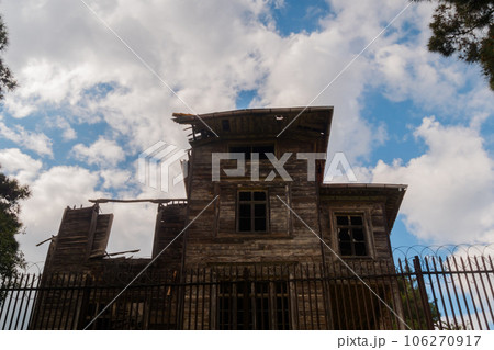 View of white clouds over old ramshackle historic wooden building 106270917