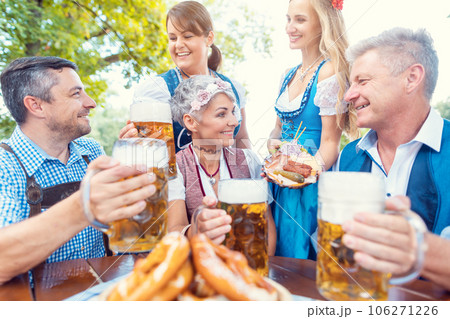 Group of friends in beer garden toasting to camera 106271226