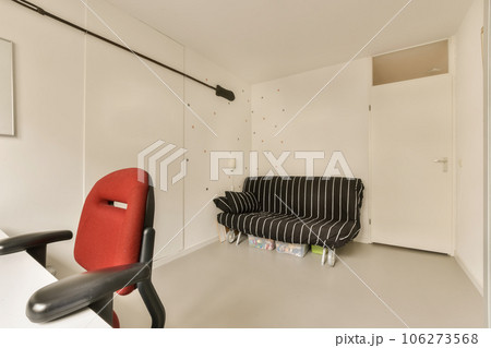 a living room with a black and white striped couch, red chair, and wallpapers on the walls 106273568