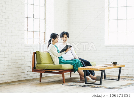リビングのソファーでタブレットを見る男女カップル 106273853