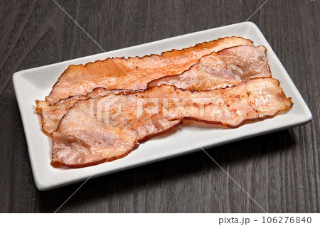 フライパンで焼いた薄切りベーコン 106276840