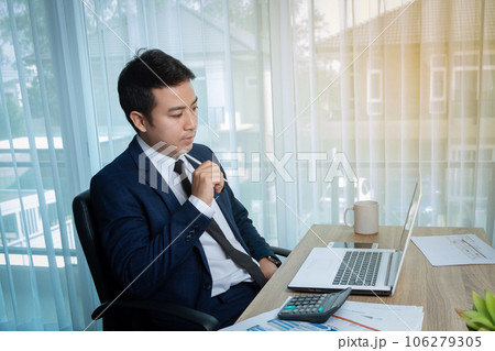 Businessman thinking while working 106279305