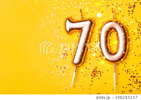 70 years celebration. Greeting banner. Gold candles in the form of number forty on yellow background with confetti. 70 years celebration. Greeting banner. Gold candles in the form of number forty on yellow background with confetti. 106283237