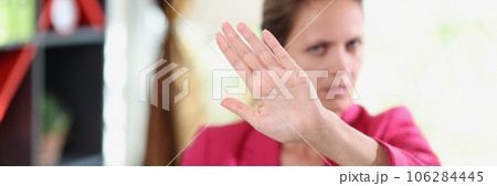 Serious female manager showing disagreement gesture while sitting in office. Serious female manager showing disagreement gesture while sitting in office. 106284445