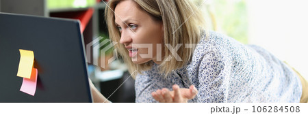 Frustrated business woman looking at computer screen in her office. Frustrated business woman looking at computer screen in her office. 106284508