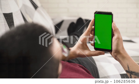 Person holding a mobile phone with a green screen, ready to replace it with any content 106285636