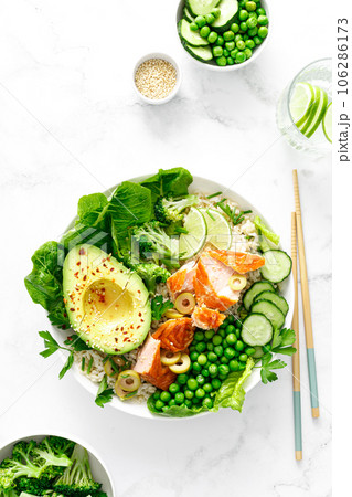 Salmon avocado bowl with broccoli, green peas, rice and fresh salad. Healthy food, top view 106286173