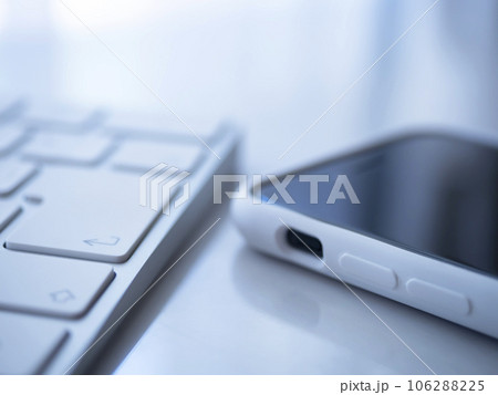 テーブルに置かれたキーボードとスマートフォン 106288225