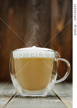 hot cappuccino in glass cup on grey wooden table hot cappuccino in glass cup on grey wooden table 106290287