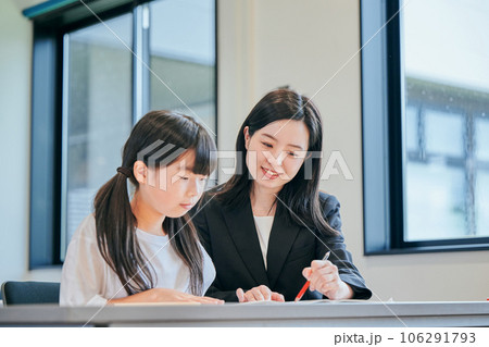 小学生に勉強を教える若い塾講師 小学生に勉強を教える若い塾講師 106291793