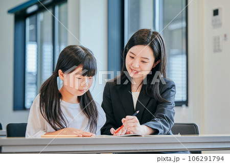小学生に勉強を教える若い塾講師 106291794