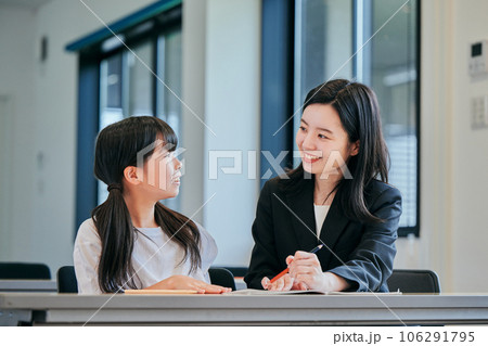 小学生の女の子と若い塾講師 106291795