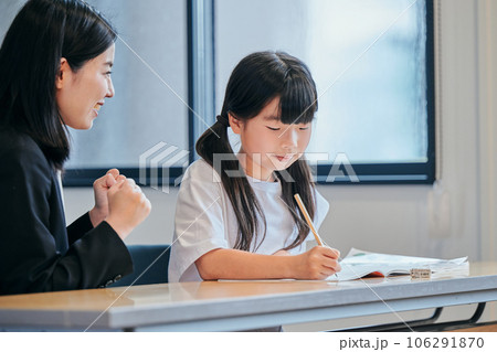 塾で先生に励まされる小学生の女の子 塾で先生に励まされる小学生の女の子 106291870